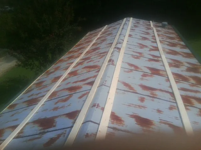 Rusted metal roof panels with new wood purlins before replacement — Storm Damage Roof Repair in Brunswick by Roofing Brothers